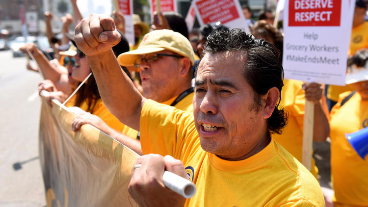 Oscar Gonzalez, a Ralphs produce worker in Hollywood, marches with grocery workers and supporters Tuesday to demand a new contract. (Michael Owen Baker / For The Times)