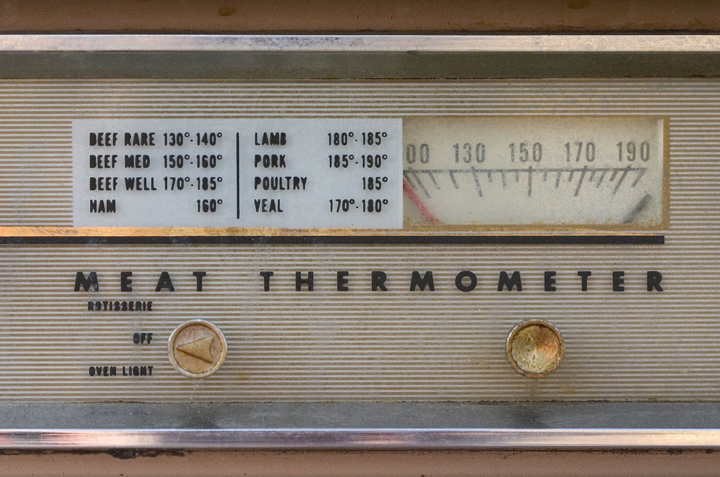 A vintage meat thermometer displays safe cooking temperatures