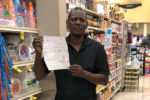 UFCW Local 400 member Eric Jarett holds up a check