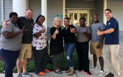 Peach Tree Acres workers pose together and give thumbs up