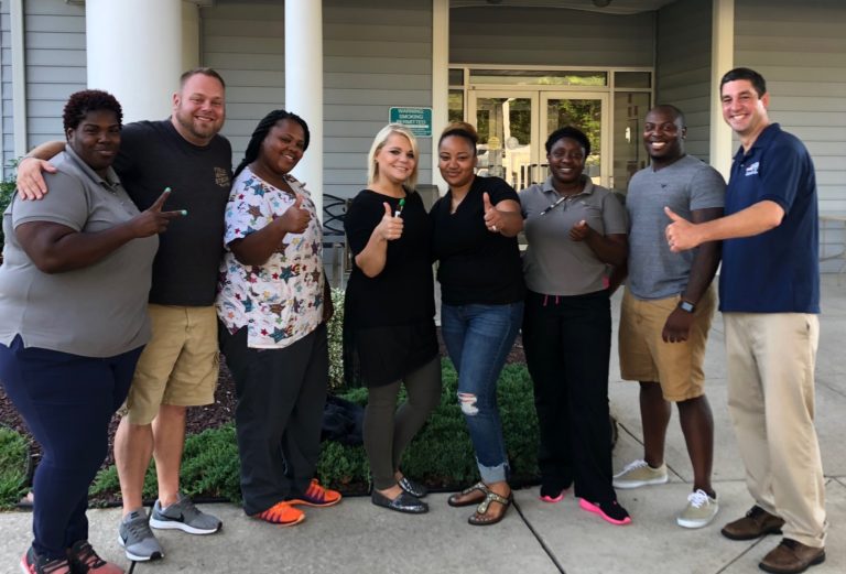 Peach Tree Acres workers pose together and give thumbs up