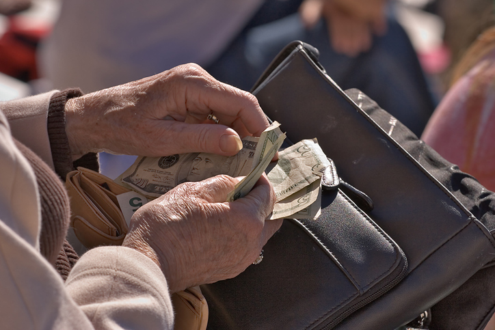 Elderly money is counting the money in her purse