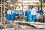 Two women who are UFCW 1149 members in a meatpacking plant