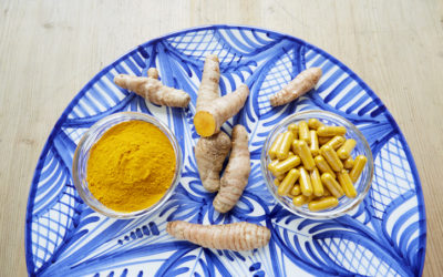High angle view of turmeric root, powder and pills on plate