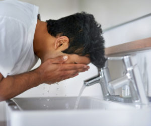 man washing his face